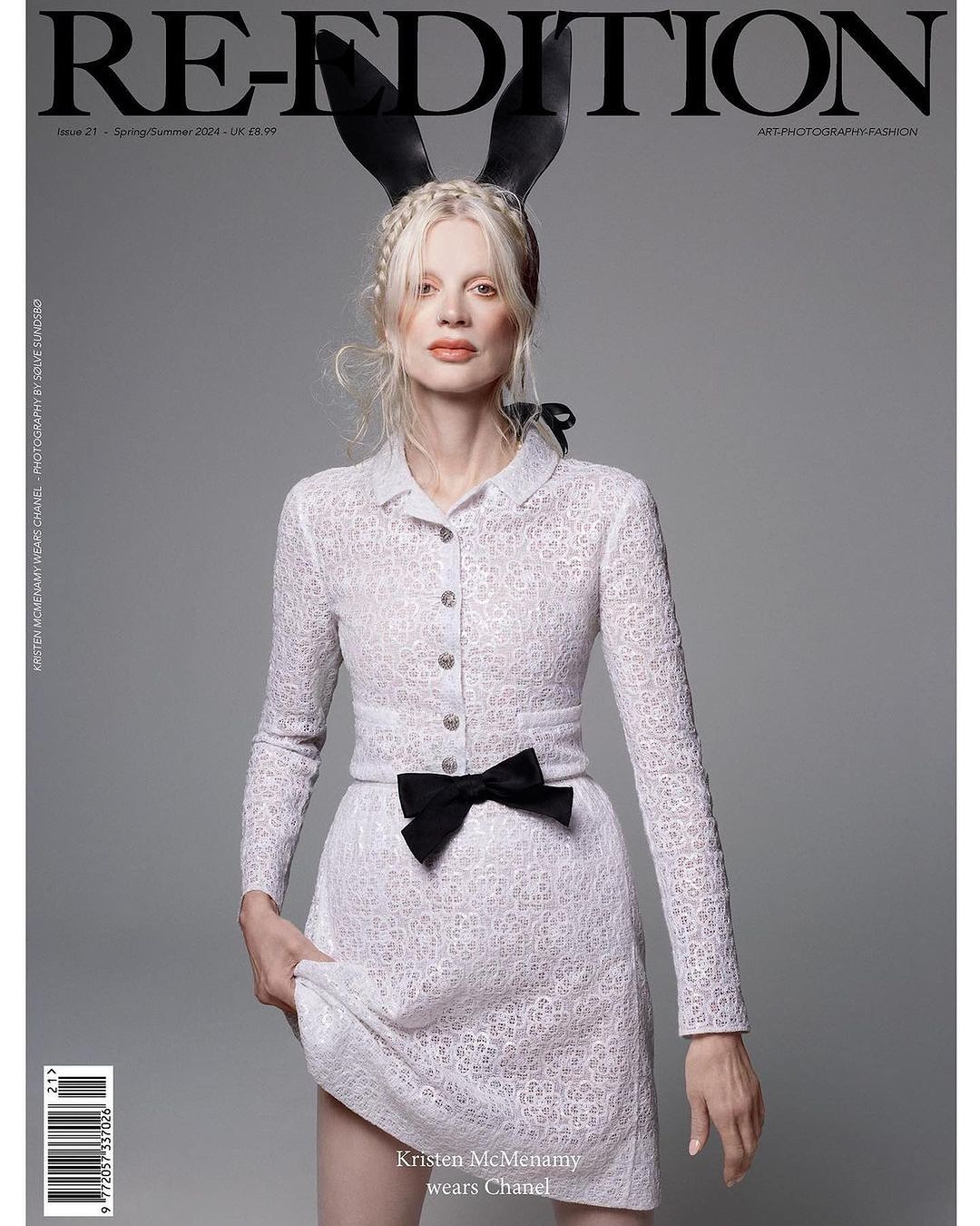 Magazine cover featuring a model with blonde hair wearing bunny ears and a white dress with a black bow, posing against a gray backdrop.