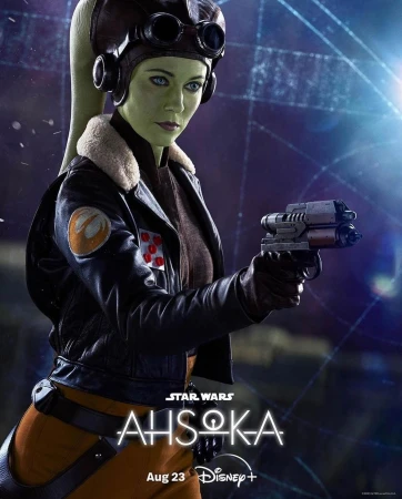 Green-skinned female pilot holding a blaster pistol, wearing a leather jacket, goggles, and headgear in a cinematic portrait.