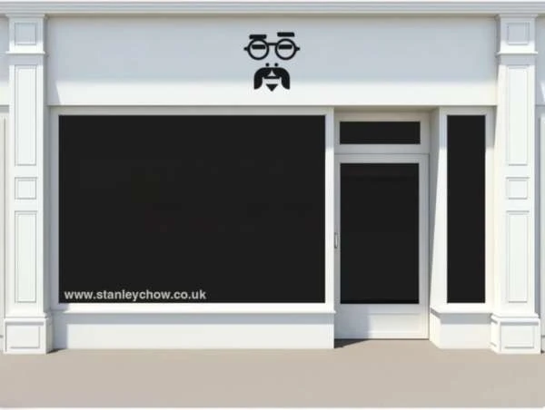 Exterior of a building with a blacked-out storefront and a logo of a face above the storefront window, along with a website address below.