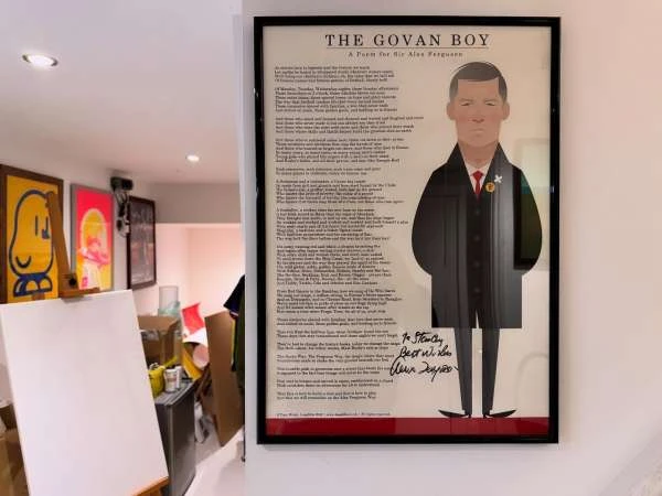 Framed illustration of a man with long poem text, hanging on a white wall in an indoor setting. Art and interior decor.