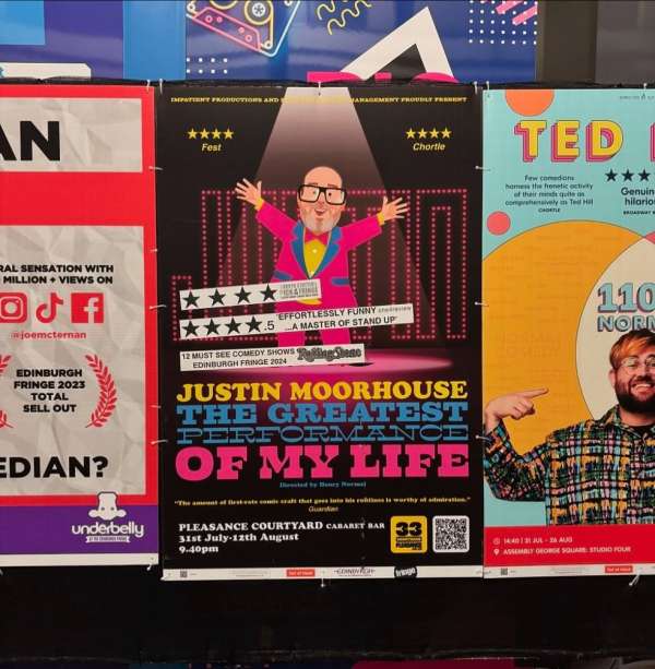 Close-up of posters for comedy shows, including Justin Moorhouse, with star ratings and performance dates. Show titles prominent.