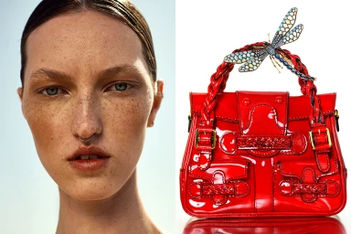 Close-up of woman with freckles next to a glossy red patent leather handbag featuring a jeweled dragonfly handle by Sandy Karagianni