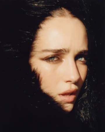 Close-up portrait of a woman with dark hair framing her face, dark eyeliner, and a serious expression by Stanislaw Boniecki