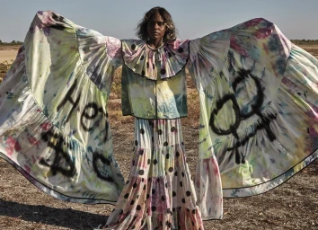 Model wearing a tie dye dress with massive ruffled sleeves outdoors styled by Charlotte Stokes in Sydney