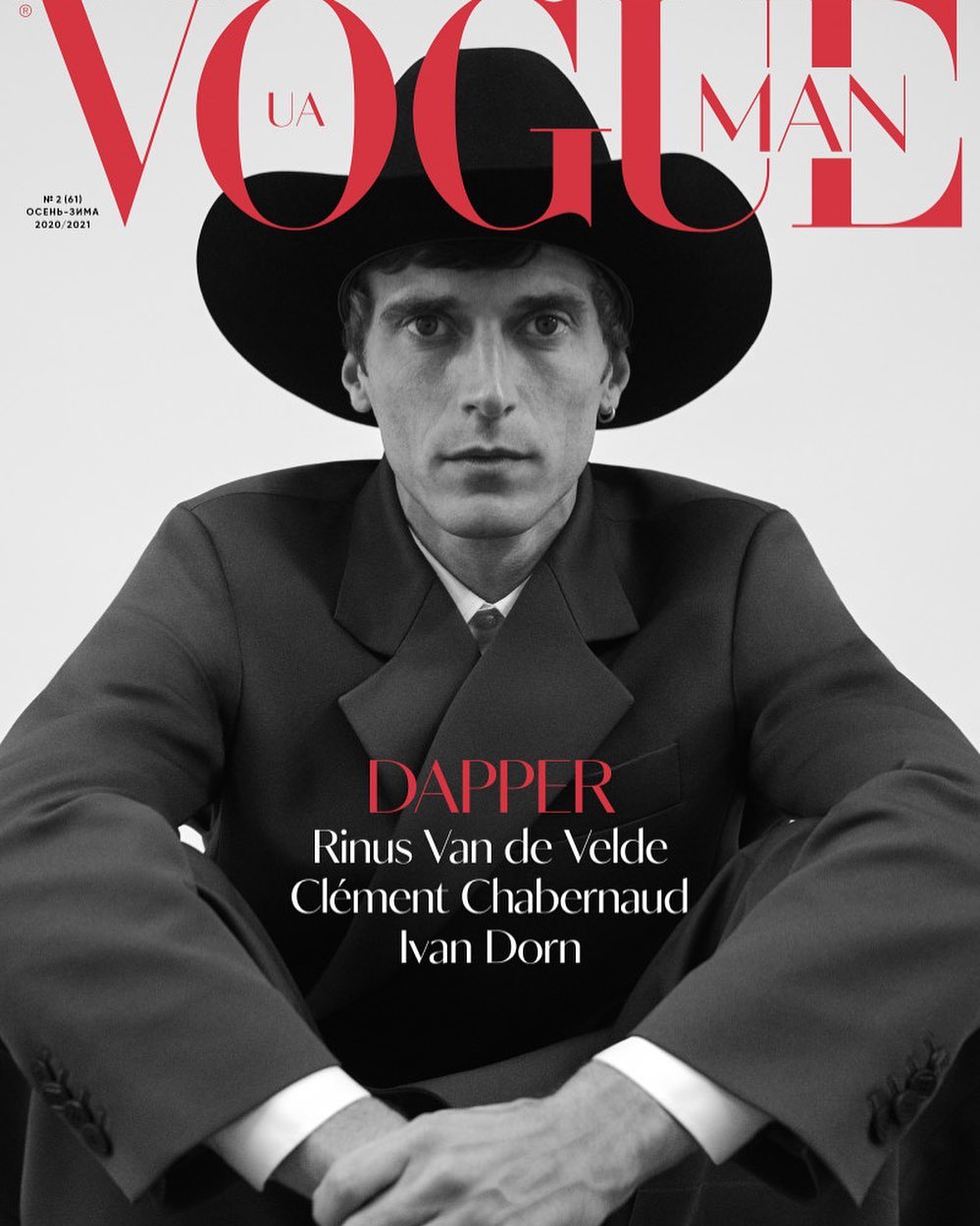 Vogue Man UA cover featuring a male model in a dark suit and wide-brimmed hat against a clean background, promoting 'Dapper' style.