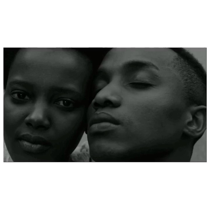 Intimate portrait of an African-descent couple in a close-up shot with a shallow depth of field, emphasizing connection and shared moment.