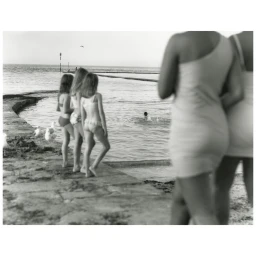Monochrome photograph of children looking out at a pool with figures in the foreground by Stefan Heinrichs