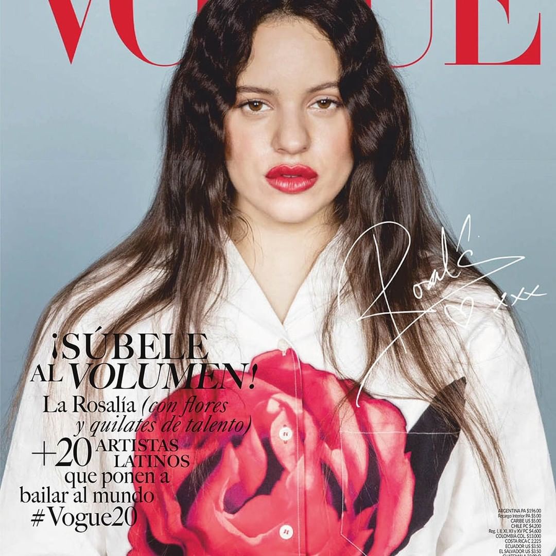 Vogue cover featuring Rosalía with long dark hair, red lips, and a white shirt adorned with a large red rose. Magazine text is visible.