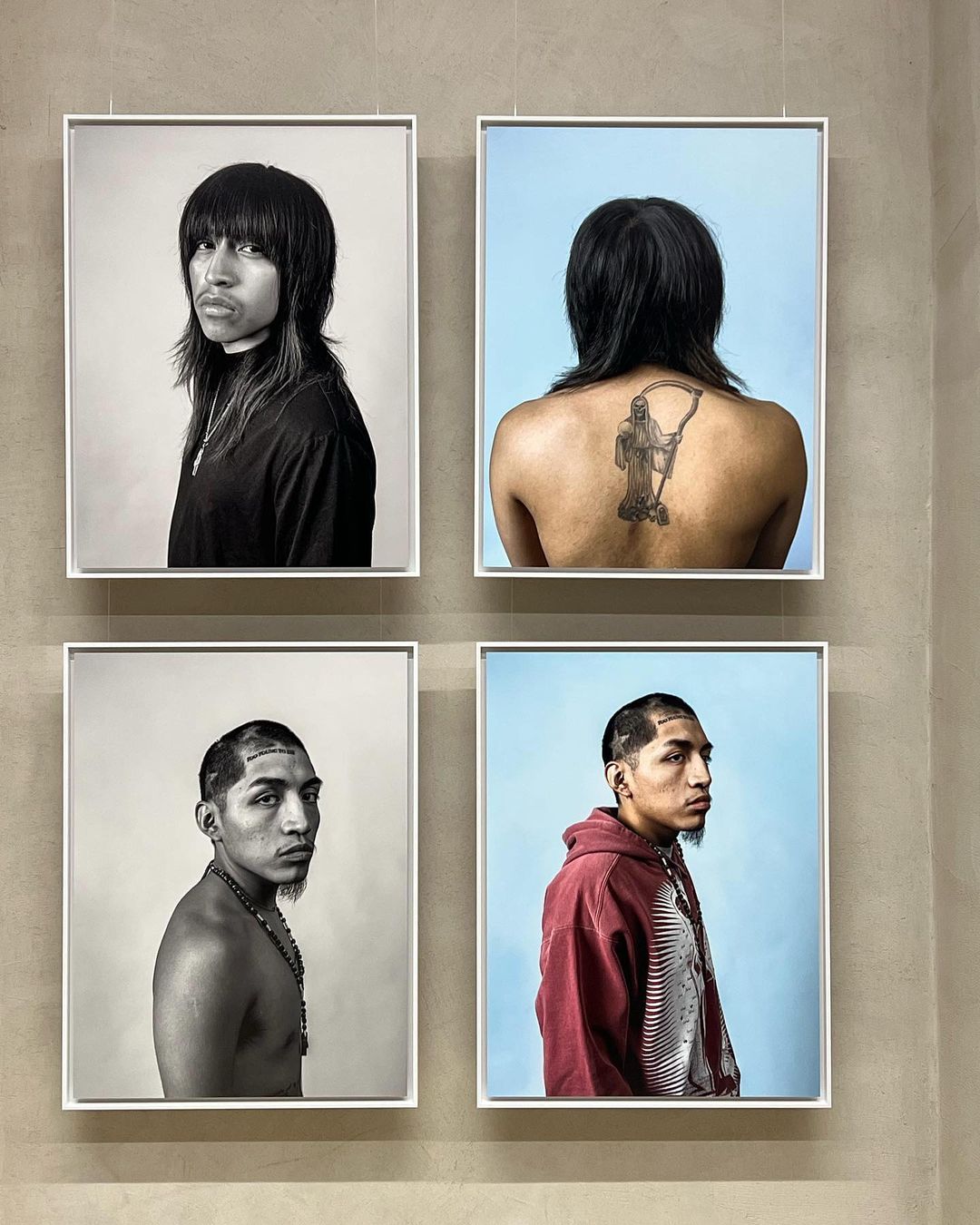 Four framed portraits hang on a neutral wall, showcasing diverse individuals with distinct hairstyles and expressions in a gallery setting.