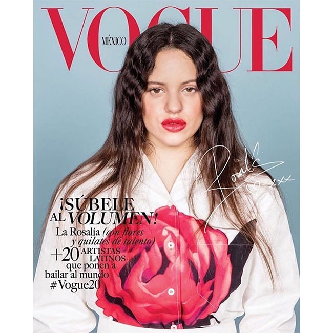 Rosalía on Vogue Mexico cover: portrait of the singer with shoulder-length dark hair, red lips, wearing white top with rose design on a blue background.