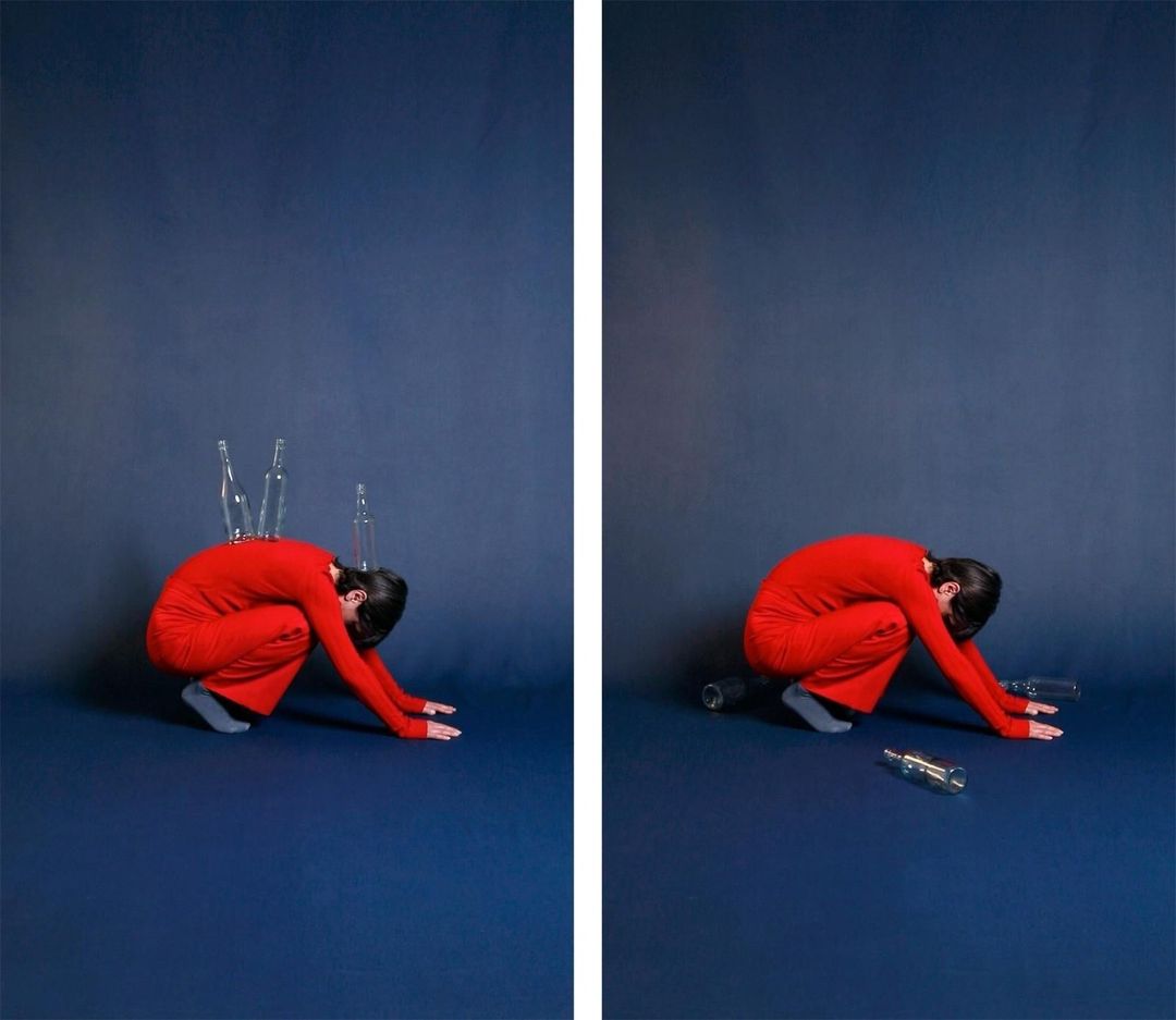 Artistic diptych image shows a woman in red crouching on a blue background, with empty bottles on her back and around her.