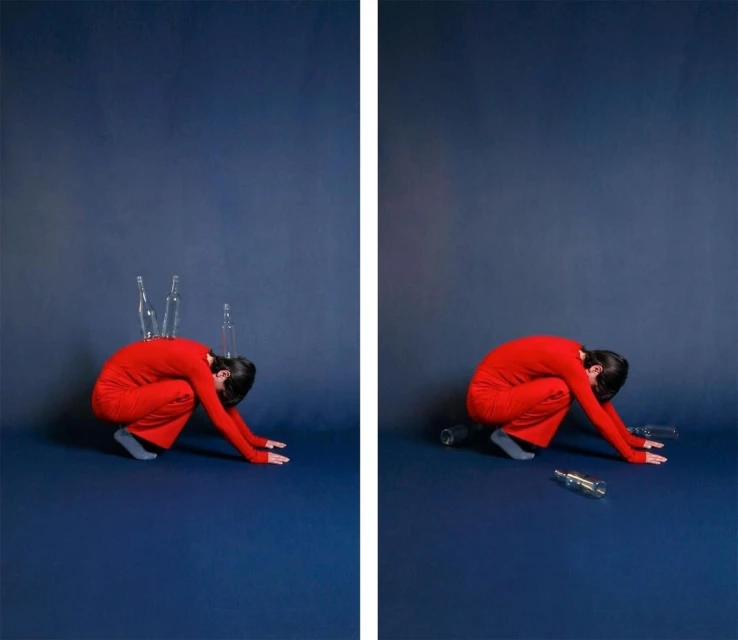 Artistic diptych image shows a woman in red crouching on a blue background, with empty bottles on her back and around her.