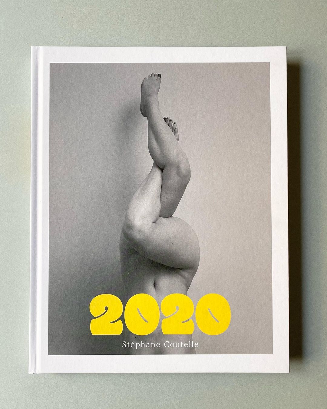 Photo book cover featuring legs and feet in the air with text "2020 Stéphane Coutelle" against a neutral grey background and white border.