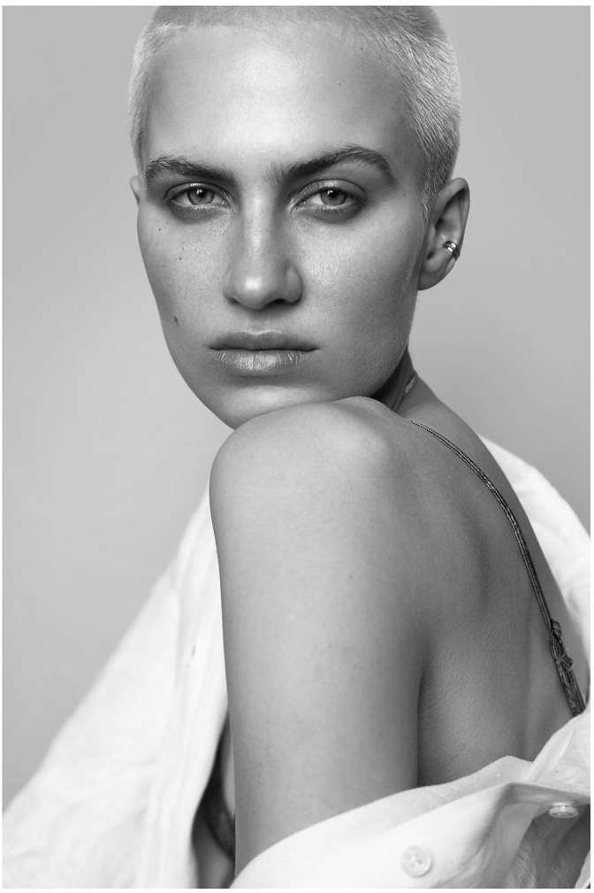 Close-up portrait of a woman with short blonde hair and a white collared shirt by photographer Stephane Coutelle