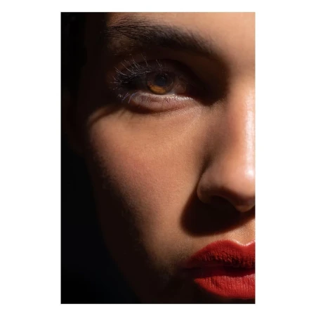 Close-up portrait of a woman's face with red lipstick and dramatic hard light by Stephane Coutelle