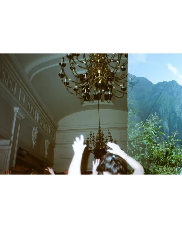 Indoor scene with a chandelier and people contrasted with an outdoor mountain landscape with lush vegetation under a bright blue sky.