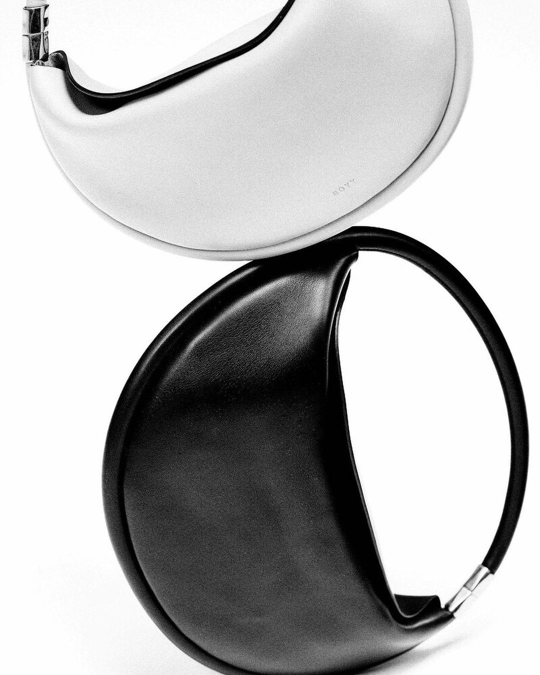 Elevated product shot of a black and white BOYY Wonton bag, sleek modern fashion accessory in a minimalist setting on an isolated background.