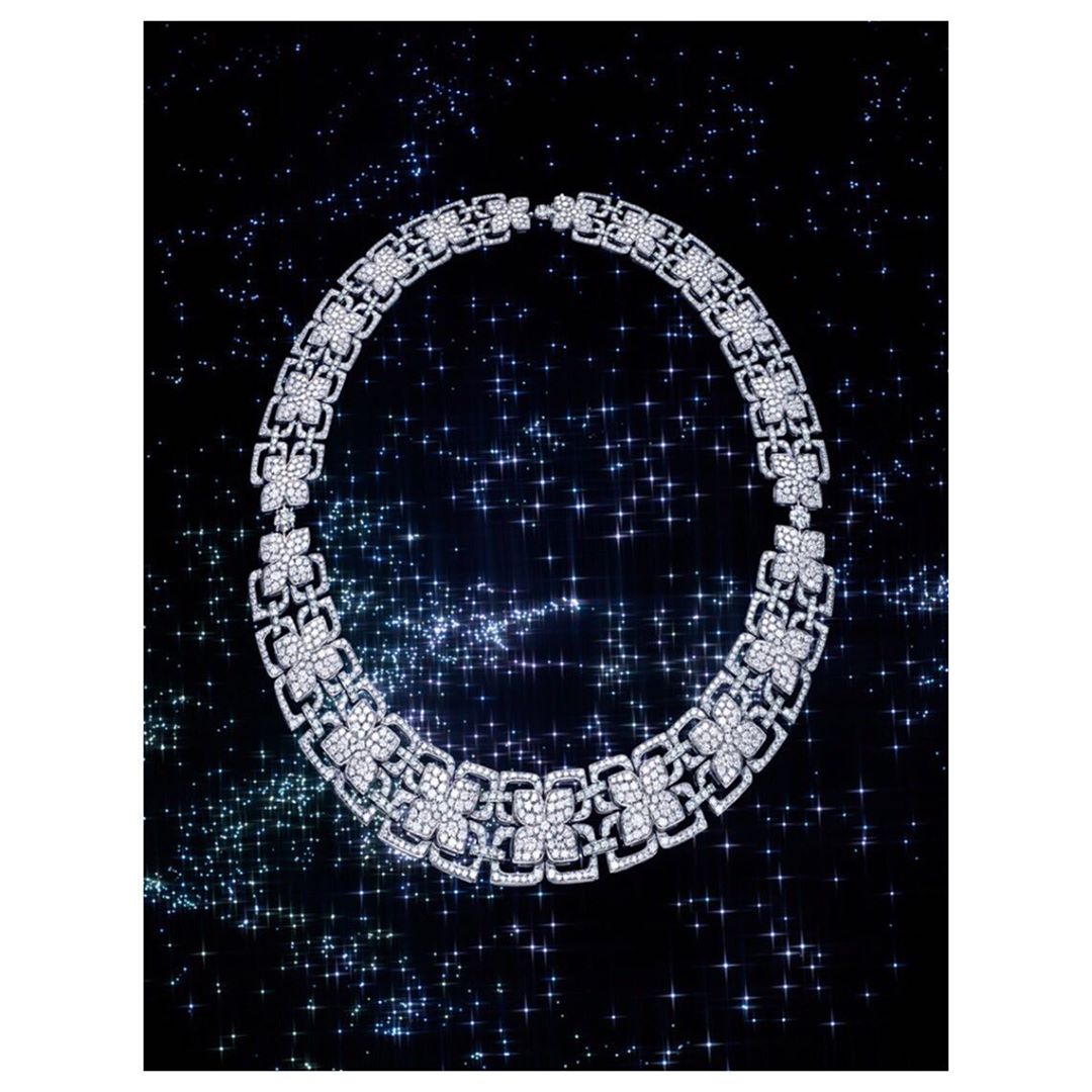 Elegant diamond necklace on black background with sparkling blue and white star-like bokeh for a luxurious, high-end fashion jewelry campaign.