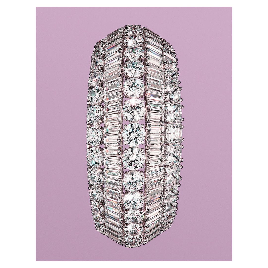 Diamond bracelet featuring round and baguette-cut diamonds in a multi-row setting on a light purple background.