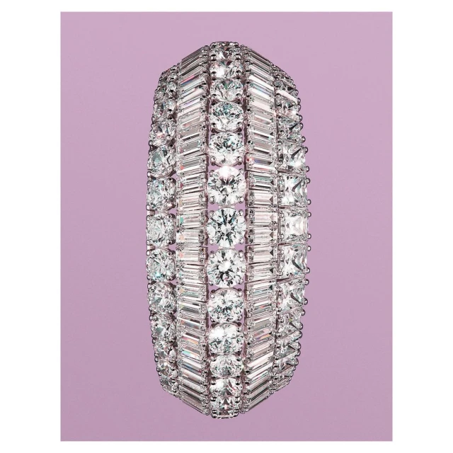 Diamond bracelet featuring round and baguette-cut diamonds in a multi-row setting on a light purple background.