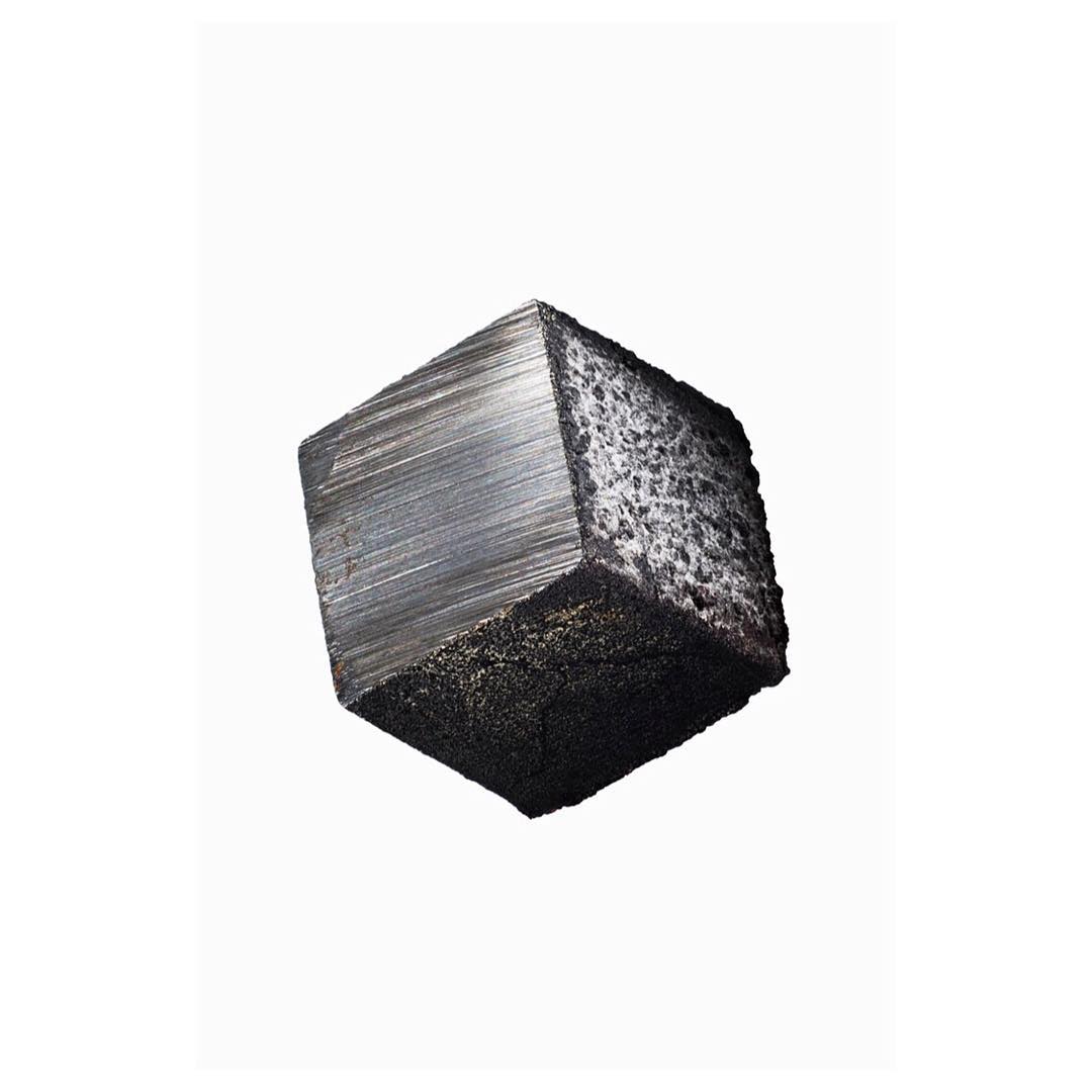Dark metallic cube on white background. Faceted and textured, this block shows detail in material and minimalist design.
