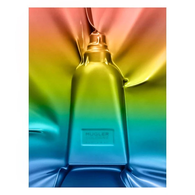 A modern fragrance bottle with a unique trapezoid shape. The bottle features a smooth, shiny surface with a gradient color scheme.