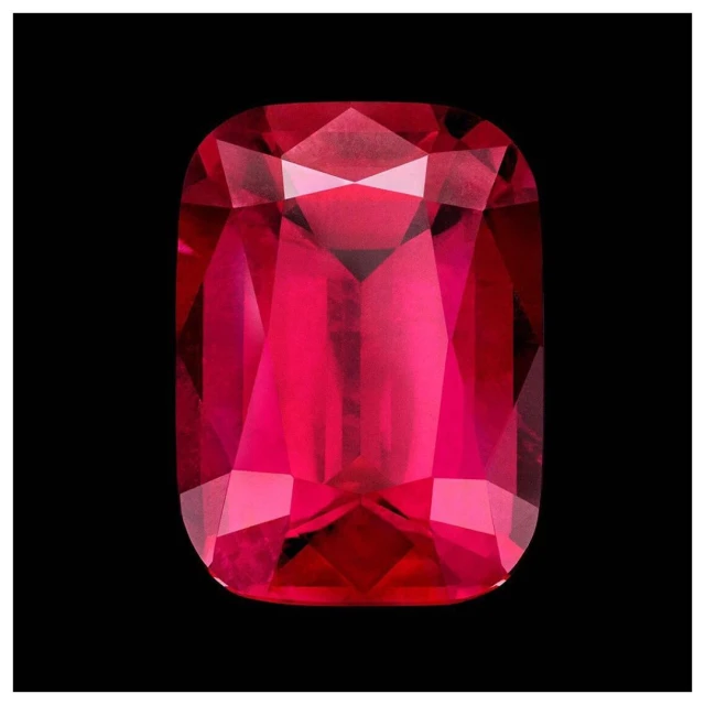 Rectangular ruby gemstone on a black background with visible facets and reflective light. Gem cut for jewelry design.