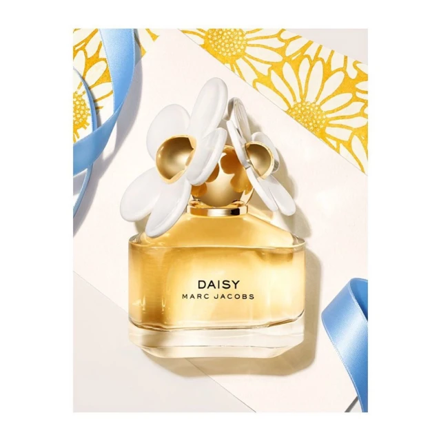 Close-up studio shot of a 'Daisy Marc Jacobs' perfume bottle featuring a white floral cap and golden liquid, accented with light blue ribbon.