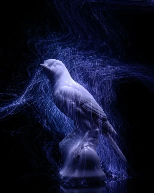 Illuminated ceramic bird figurine on a reflective surface against a dark backdrop with blue light trails around the bird.
