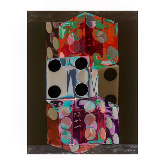 Abstract still life featuring a vertical stack of three translucent cubes with geometric designs and colorful patterns on a neutral backdrop.
