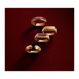 Four gold rings arranged diagonally against a dark red textured background, photographed by Stephen Lewis.