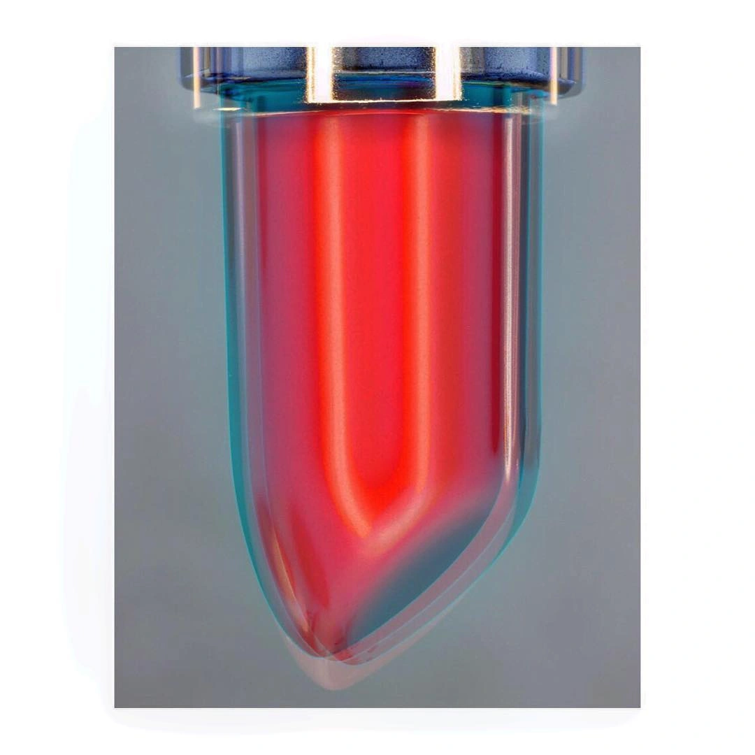 Macro shot of a red lipstick bullet showing chromatic aberration and glow against a grey gradient background