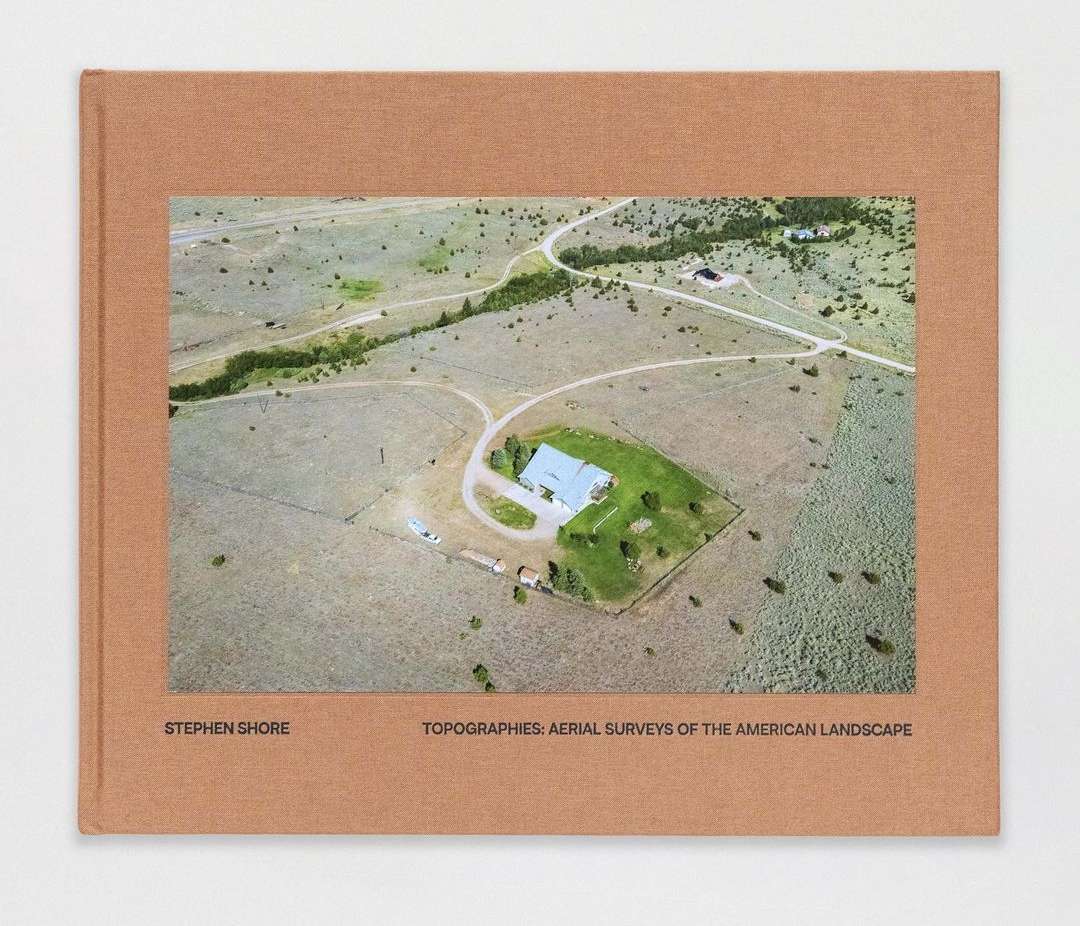 Stephen Shore's "Topographies: Aerial Surveys of the American Landscape" book cover featuring a rural aerial view of a house and fields.