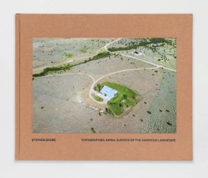 Hardcover book with tan fabric cover displaying an aerial landscape photograph on the front by photographer Stephen Shore.