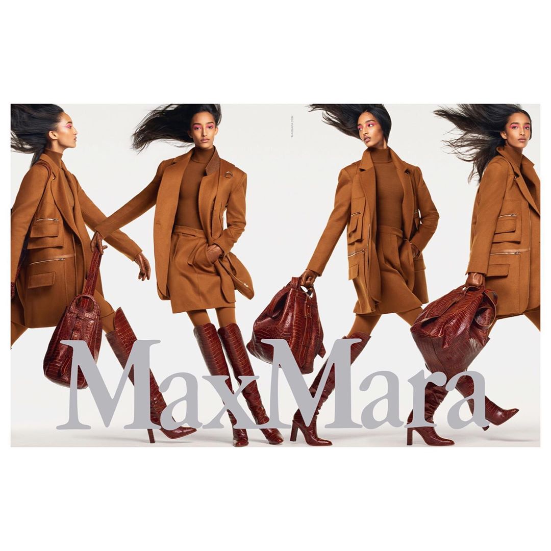 Fashion editorial features a model showcasing Max Mara clothing in a studio setting, wearing a brown coat, dress, boots, and carrying a purse.
