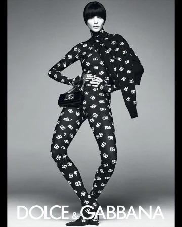 Model in black and white patterned catsuit wearing matching heels and holding a handbag by Steven Meisel