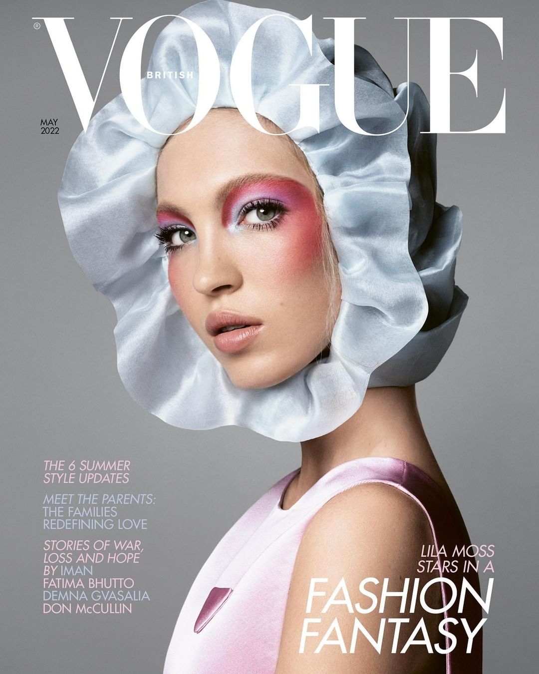 Vogue cover featuring a model wearing a light blue bonnet, pink blush, and a light pink dress against a light gray backdrop.