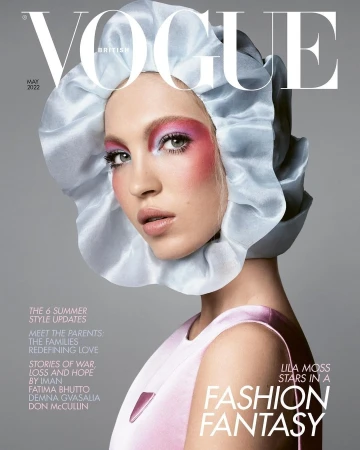 Vogue cover featuring a model wearing a light blue bonnet, pink blush, and a light pink dress against a light gray backdrop.