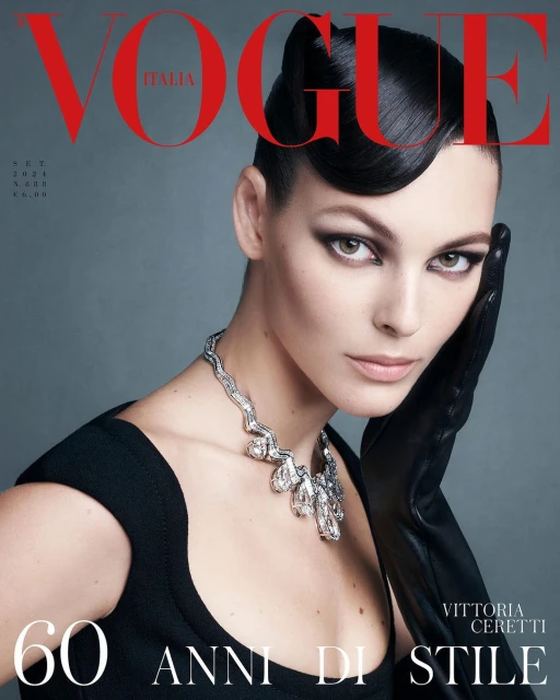Vittoria Ceretti graces the Vogue Italia cover with a sleek hairstyle, statement necklace, black top, and gloves against a grey backdrop.