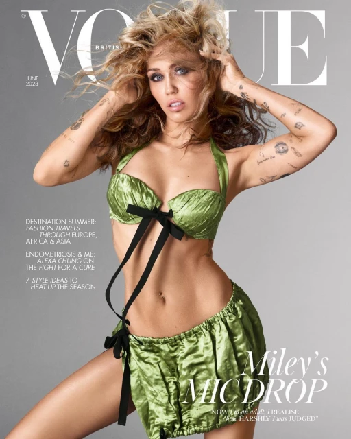 Miley Cyrus on the cover of British Vogue, June 2023. She poses in a green satin lingerie set with dark bows against a grey backdrop.