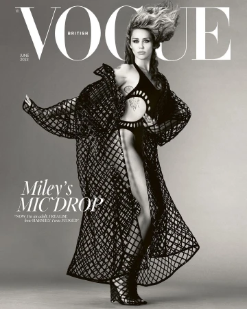 Miley Cyrus on the cover of British Vogue June 2023, wearing a black cut-out bodysuit and matching net-like long coat and gladiator heels.
