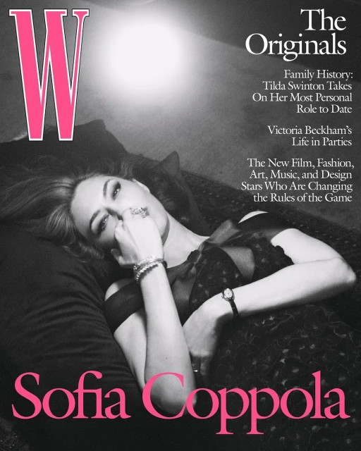 Sofia Coppola lies on a black pillow with a black and grey dress, a silver bracelet, and a ring, magazine cover