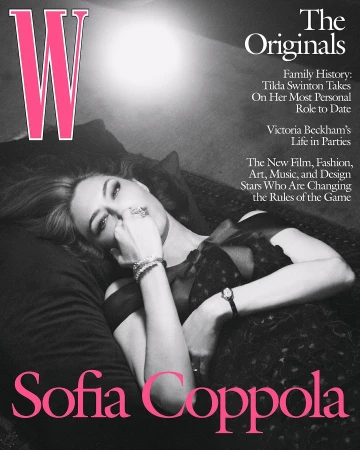 Sofia Coppola lies on a black pillow with a black and grey dress, a silver bracelet, and a ring, magazine cover