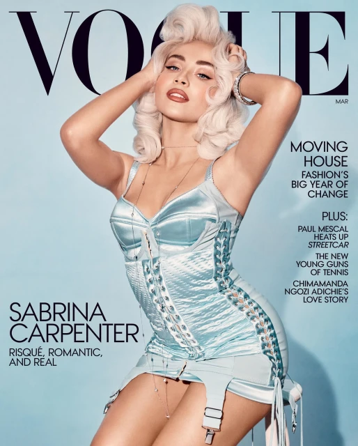 Vogue magazine cover featuring Sabrina Carpenter in a blue, vintage-style outfit, with blonde hair and bold makeup, against a light blue background.