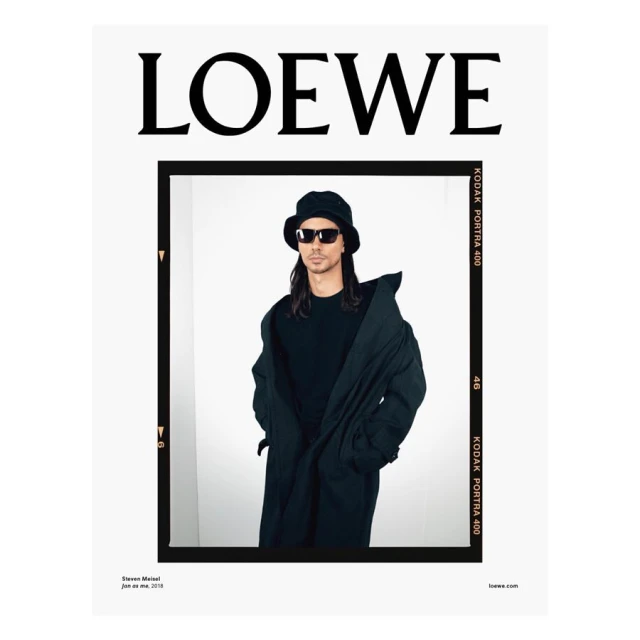 Fashion advertisement featuring a man in sunglasses, a bucket hat, and a long coat against a white background, framed by a black border with text.
