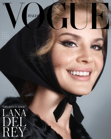 Close-up Vogue cover featuring Lana Del Rey with retro makeup and a black headscarf, smiling against a gray backdrop with magazine text.