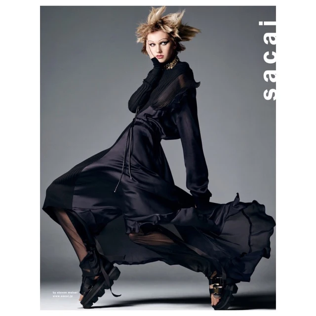 A high-fashion shot shows a model in a dark dress with a spiky hairdo, posed in a studio against a gray background, wearing chunky platform shoes.