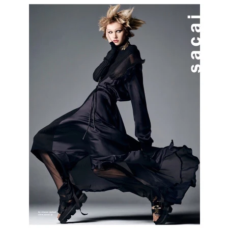 A high-fashion shot shows a model in a dark dress with a spiky hairdo, posed in a studio against a gray background, wearing chunky platform shoes.