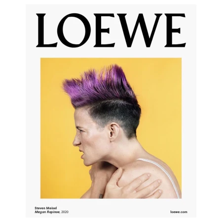 Fashion portrait of a woman with purple hair against a yellow backdrop, promoting Loewe, a fashion brand, in a studio setting.
