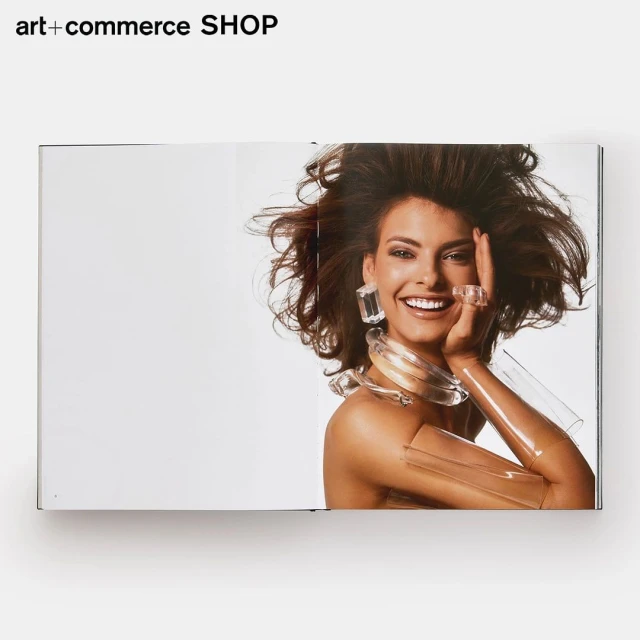 Smiling woman in jewelry featured in magazine ad, wearing transparent accessories, shoulder-up shot with bright studio lighting.